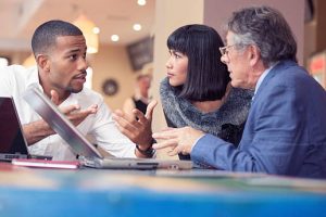 Three people talking business in a relaxed bar environment.