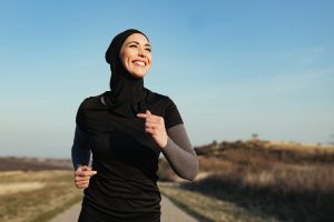 Young happy athletic woman enjoying while jogging in the morning